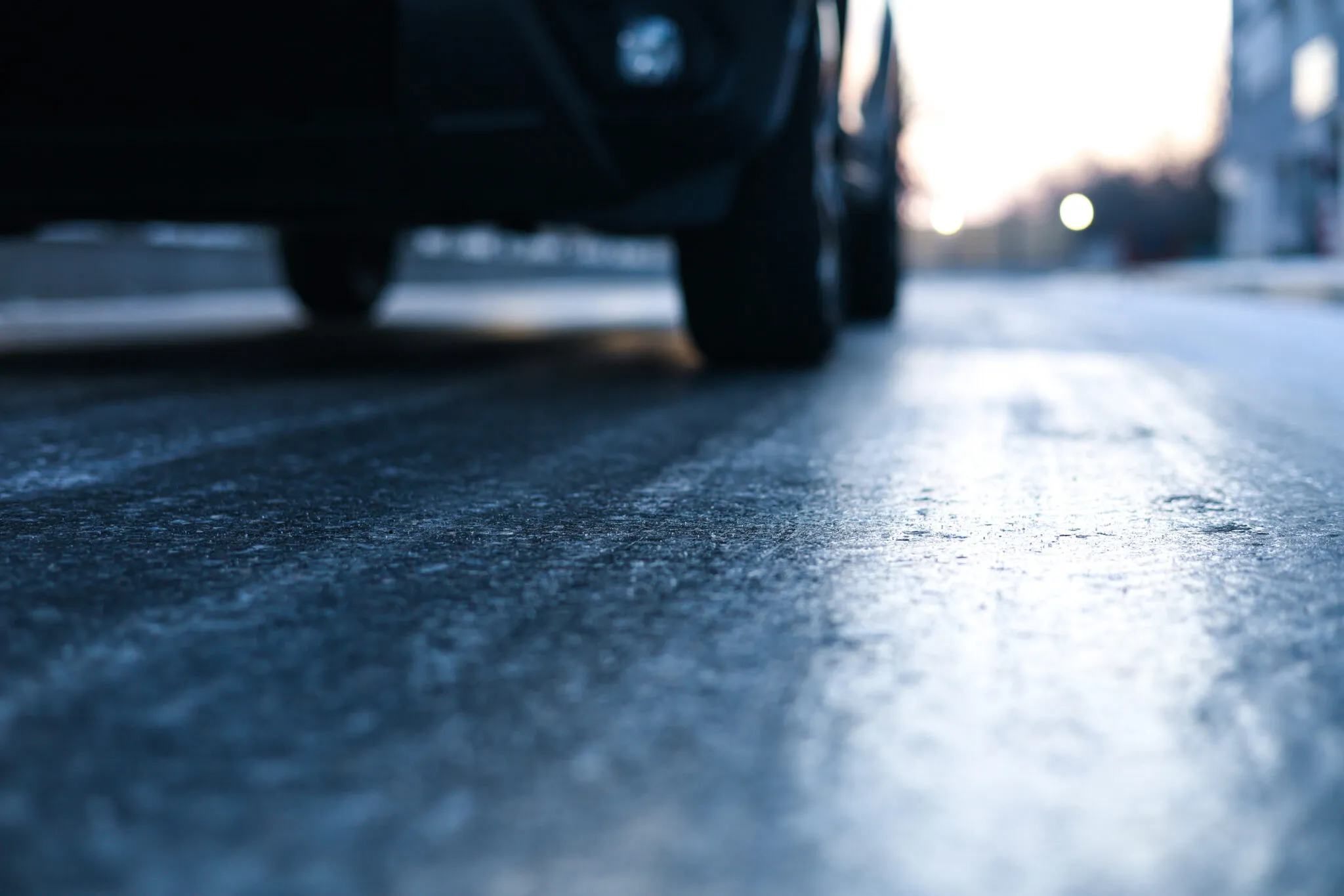 A vehicle is shown driving on a slick, icy road surface.